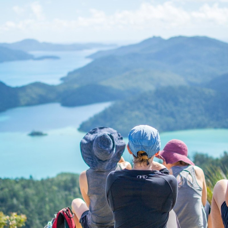 a group of people standing in front of a mountain