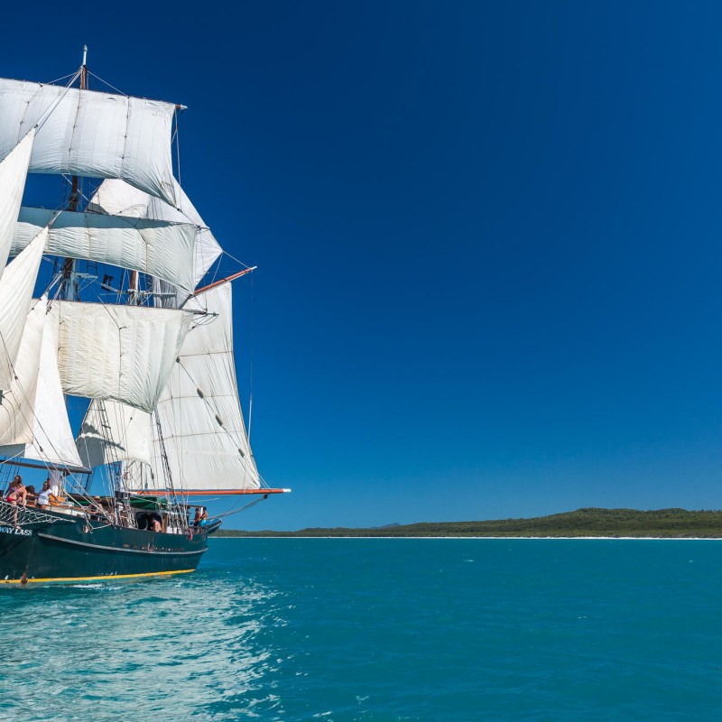 a blue and white boat sitting next to a body of water