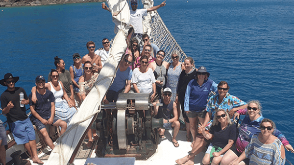 a group of people posing in front of a body of water