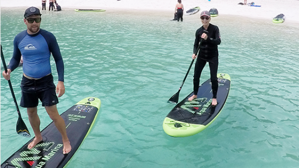 Solway Lass – Paddle boarding at Whitehaven Beach a group of people standing next to a body of water