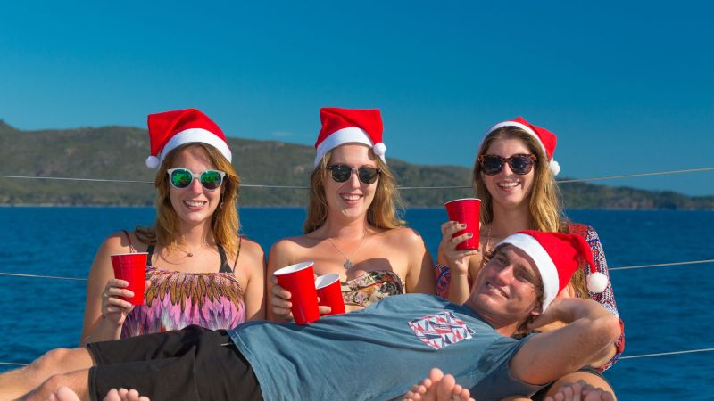 a man and woman sitting next to a body of water