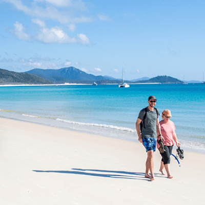 a group of people walking on a beach