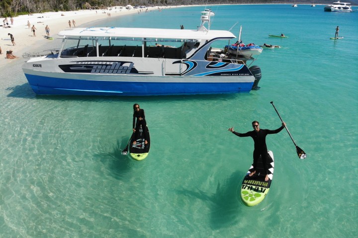 a blue and white boat sitting next to a body of water
