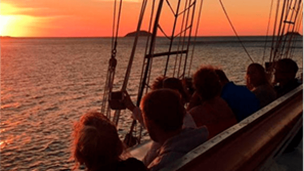 a group of people sitting in a boat on a body of water